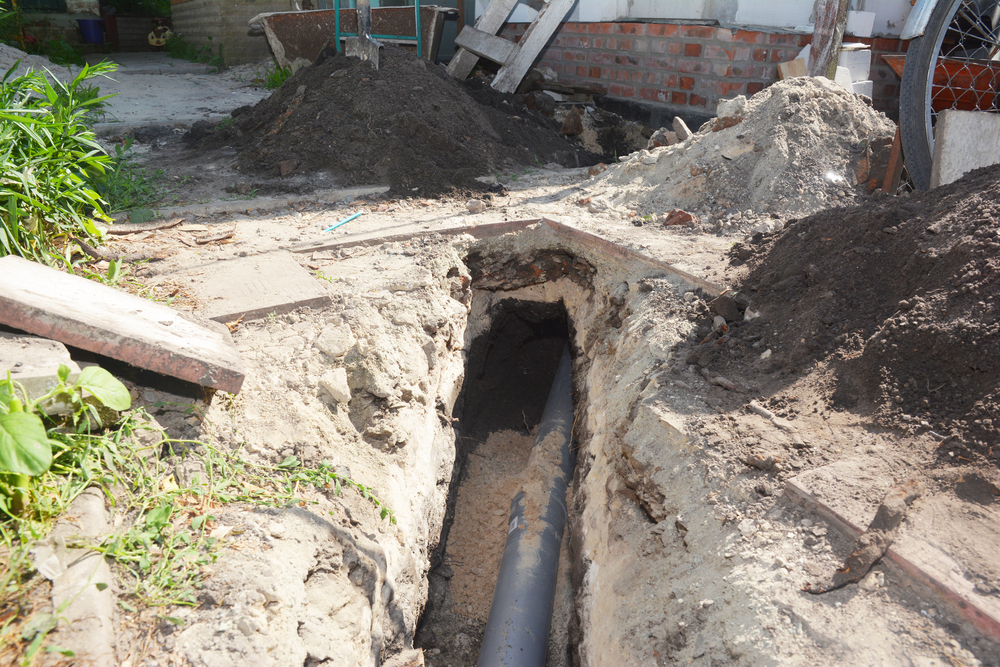 Digging a trench for a main drain pipe, sewer line to a sewer or